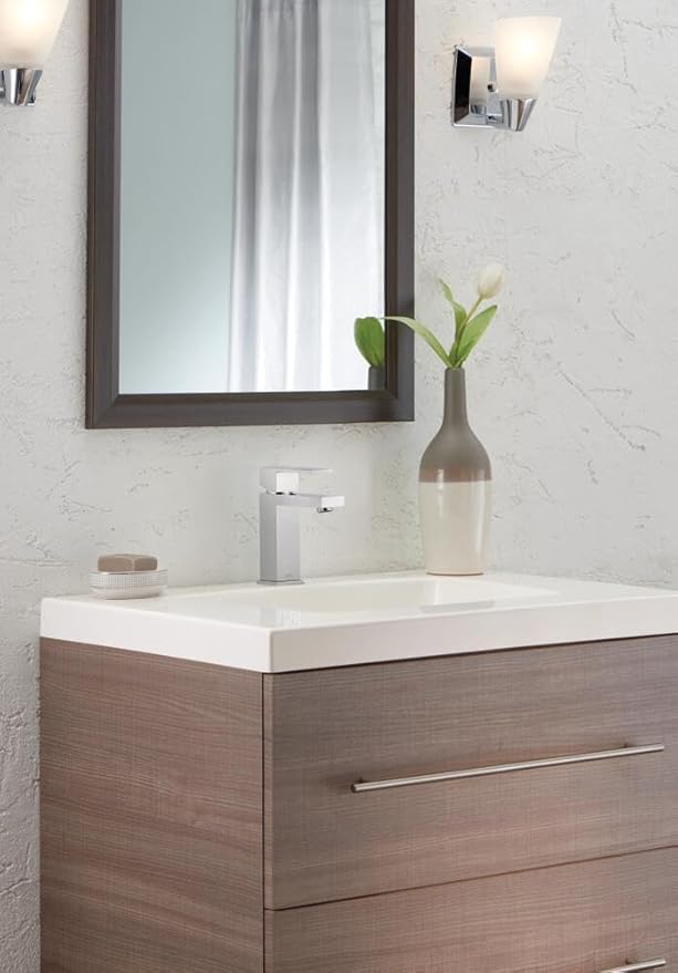 Bathroom vanity with mirror, faucet, and decorative elements.
