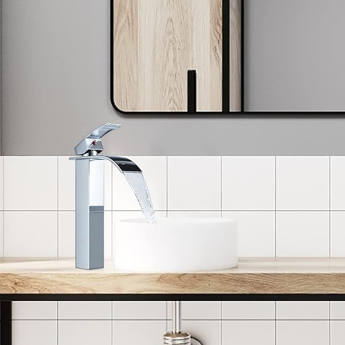 Chrome faucet on a wooden countertop with a tiled wall and mirror in the background