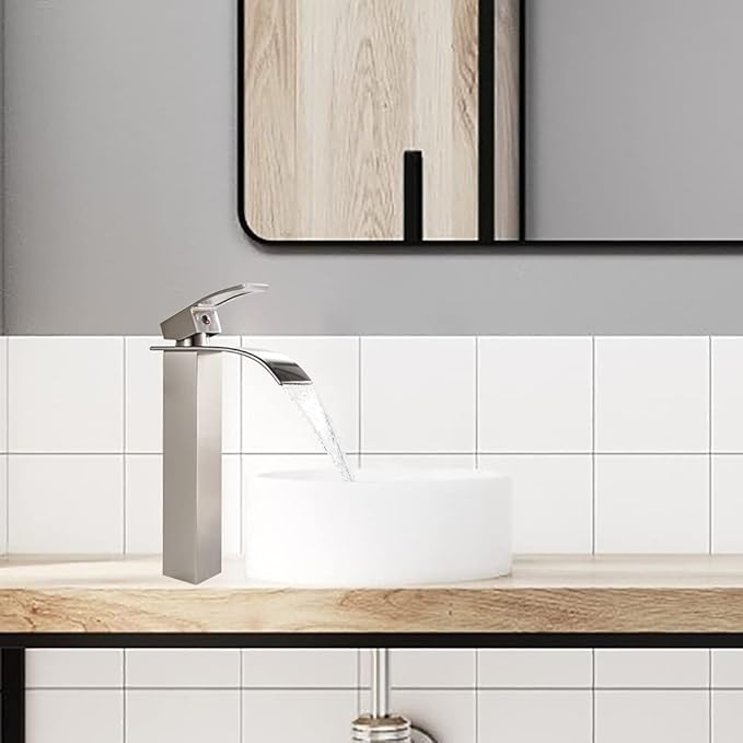 Modern bathroom sink with a silver faucet and white tiles on the wall.