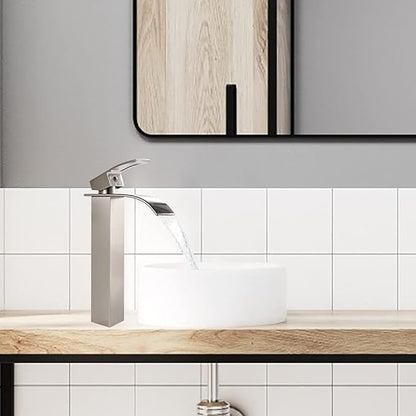 Modern bathroom sink with a silver faucet and white tiles on the wall.