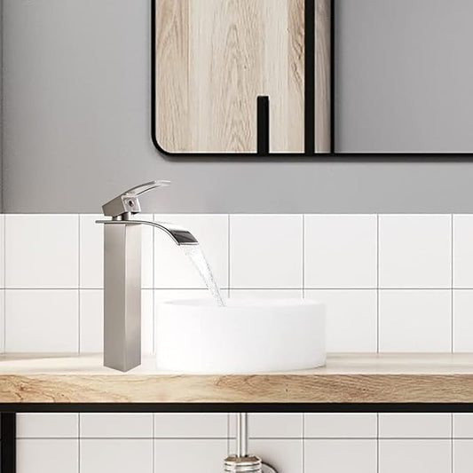 Modern bathroom sink with a silver faucet and white tiles on the wall.