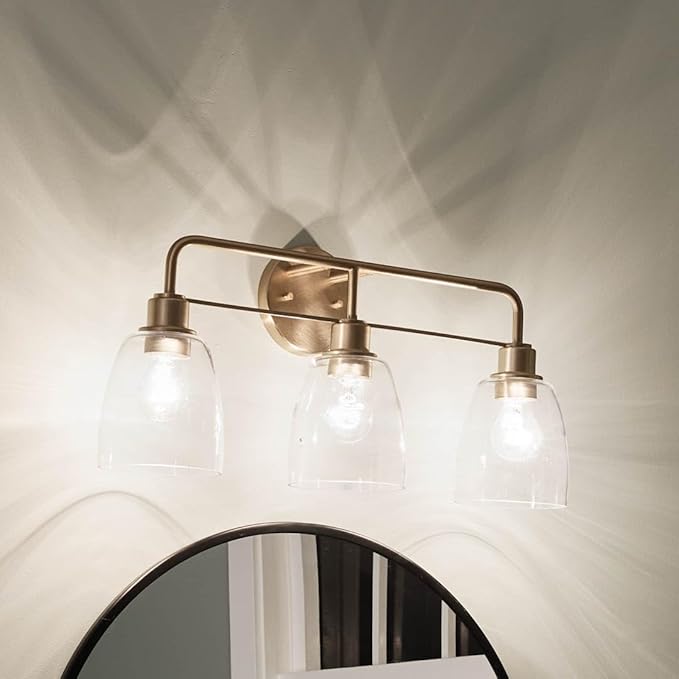 Kichler Meller 24.25 Inch 3 Light Vanity Light with Clear Glass Shades in Champagne Bronze for Bathroom or Powder Room, (24.25" W x 11.25" H x 7" D) 55102CPZ