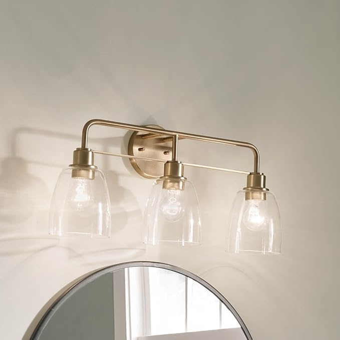 Kichler Meller 24.25 Inch 3 Light Vanity Light with Clear Glass Shades in Champagne Bronze for Bathroom or Powder Room, (24.25" W x 11.25" H x 7" D) 55102CPZ