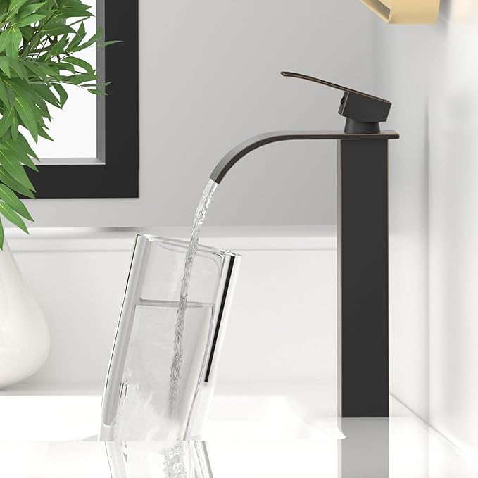 Black faucet pouring water into a clear glass with a white background and plant on the side.