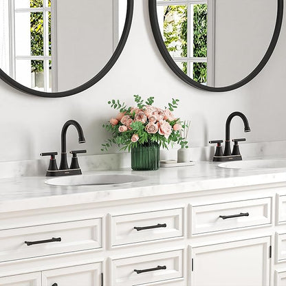 Bathroom vanity with white cabinets, black fixtures, and a vase of flowers.