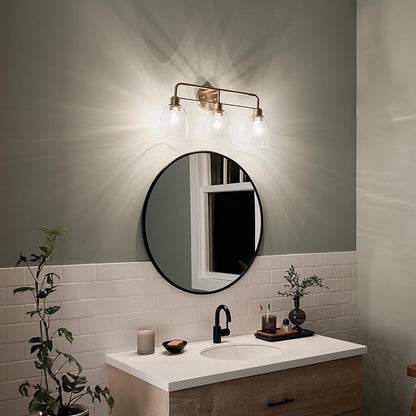 Kichler Meller 24.25 Inch 3 Light Vanity Light with Clear Glass Shades in Champagne Bronze for Bathroom or Powder Room, (24.25" W x 11.25" H x 7" D) 55102CPZ