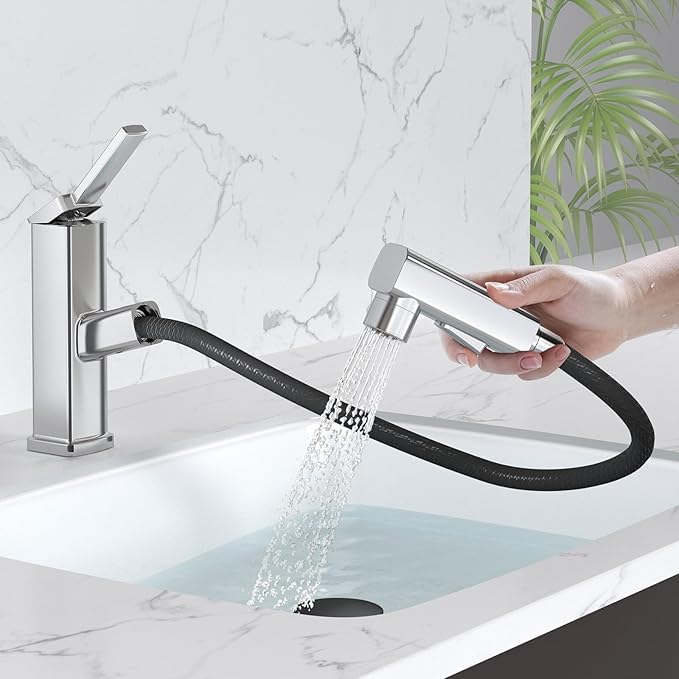 Kitchen faucet with a handheld shower head spraying water in a modern kitchen setting.