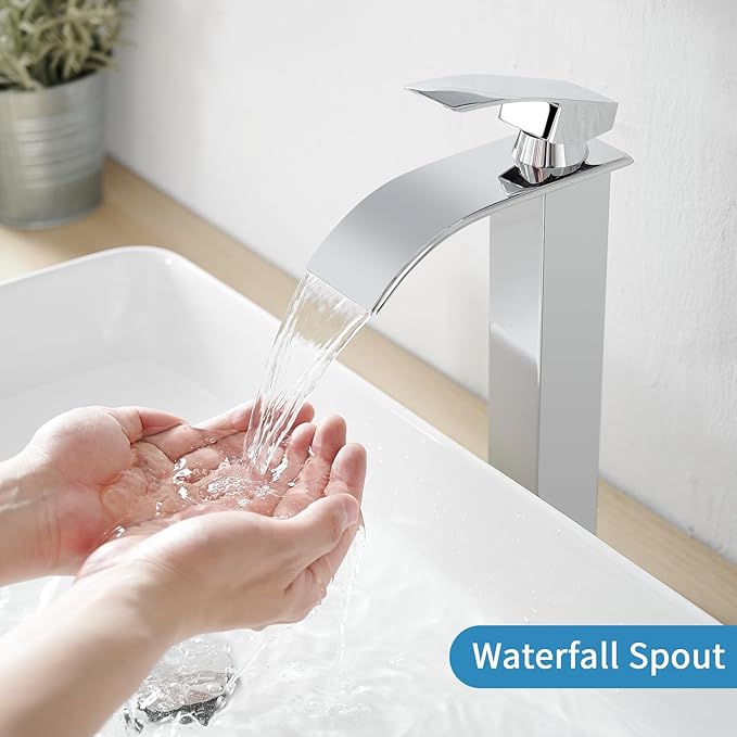 Chrome waterfall faucet with hands under running water on a white sink.