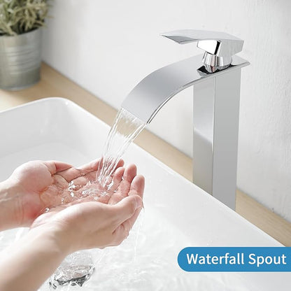Chrome waterfall faucet with hands under running water on a white sink.