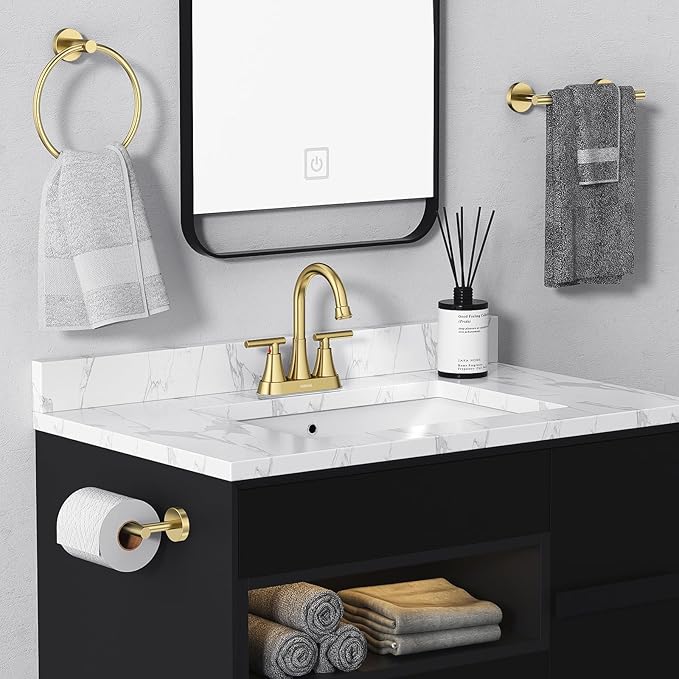 Bathroom vanity with gold fixtures, towels, and a mirror.